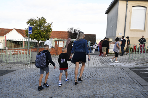 une maman accompagne ses enfants à l'école liberté